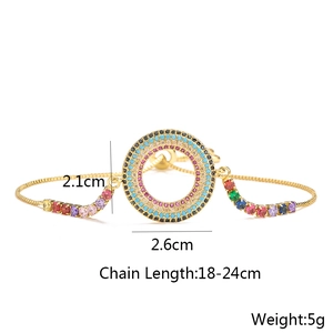 Detail of 18K gold-plated bracelet with hollow round pendant and colorful zircons