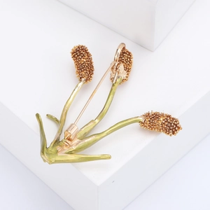 Detail shot showing the green stems and brown flower head of the botanical plant brooch