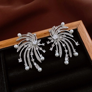 Detail shot of starburst pearl earrings with cubic zirconia on black velvet and satin
