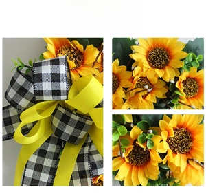 Detail showing artificial sunflower petals, green leaves and checkered bow decoration