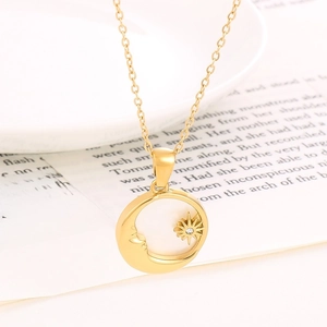 Detail van een goudkleurige maan- en sterhanger aan een fijne, elegante schakelketting