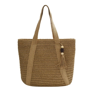 Handwoven straw tote bag with tassels and wooden beads on a clean white background