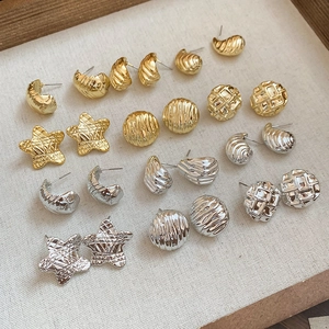 Macro view of assorted metal stud earrings with star and shell patterns in a tray