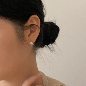 Close-up of minimalist 925 sterling silver geometric stud earrings worn on a model