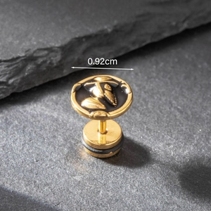 Macro view of 0.92cm gold skull earring with black enamel and top hat detail