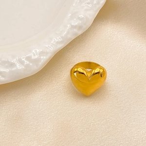 Polierter goldener Herzring mit glänzendem Finish auf elegantem Seidenstoff