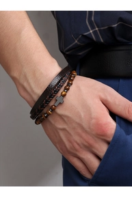 Close-up of layered men's bracelets with tiger eye stones, cross charm and woven leather