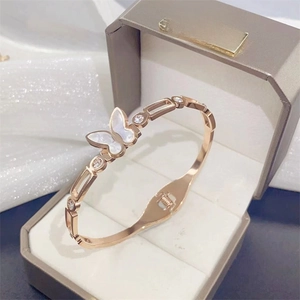 Rose gold butterfly open bangle with shell wings and crystals in a gray jewelry box