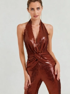 Detail of sequin fabric texture and waist twist knot on bronze halter neck jumpsuit