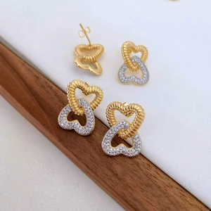 Detailed macro view of interlocking heart earrings with twisted texture and zircon inlay