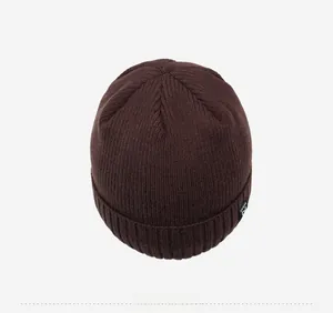 Top-down view of a dark brown ribbed knit beanie featuring thick wool blend material texture