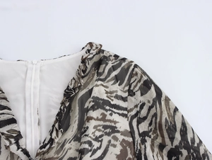 Detail of zebra print chiffon dress showing ruffled V-neckline and back zipper
