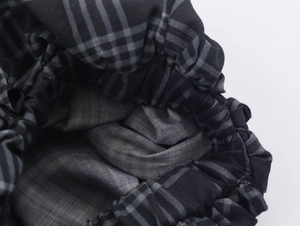 Macro shot of plaid puffed shorts fabric featuring detailed elastic pleated waist texture