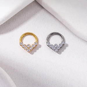 Detailed view of titanium nose rings with cubic zirconia in gold and silver finishes