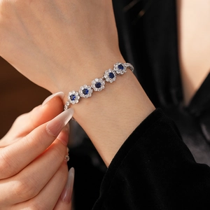 Vue détaillée du bracelet floral avec saphir bleu et zircons blancs porté au poignet