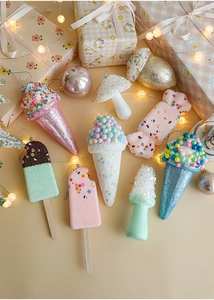 Macro detail of macaron-colored ice cream and dessert Christmas tree ornaments in a gift box