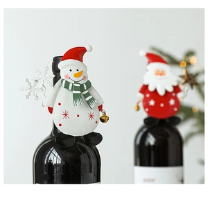 Detail of Santa and Snowman metal wine bottle toppers for festive holiday table decoration