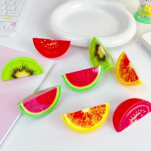 Macro shot of assorted colorful fruit slice pencil sharpeners in watermelon and kiwi designs