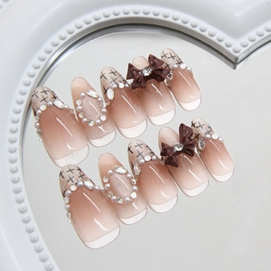 Cat eye press-on nails with bow and diamond accents on heart mirror tray