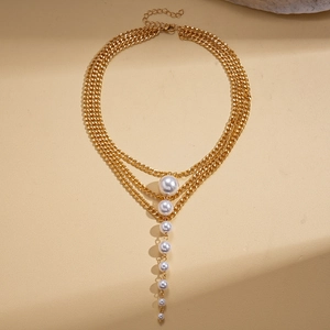 Detail of layered gold chain necklace featuring cascading pearls and lobster clasp