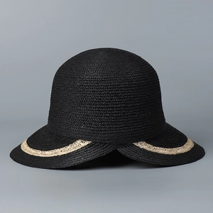 Detail of black woven raffia sun hat with split brim and contrasting beige trim accents