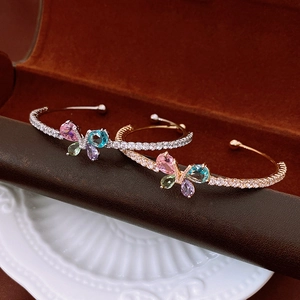Gros plan détaillé des bracelets papillon avec zircons colorés et pavé de cristaux