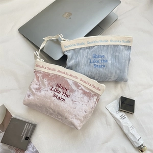 Detailed embroidery on velvet cosmetic bags featuring Shine Like the Stars text