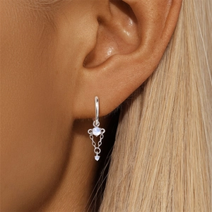 Close-up of S925 silver dangle earrings featuring moonstone gems and triple chain fringe