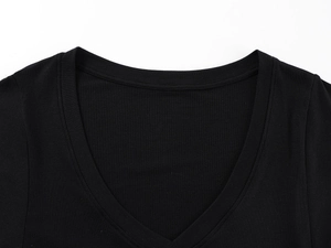 Detail of the deep V-neckline on a black ribbed t-shirt showing fine stitching