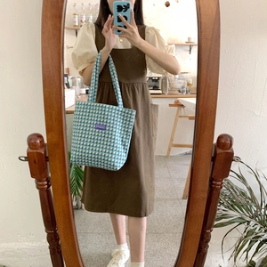 Mirror selfie showing a large blue plaid canvas tote bag with a purple woven label