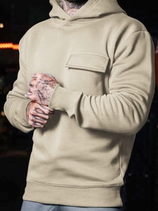 Detail view of khaki drawstring hoodie with large front flap pocket and ribbed cuffs