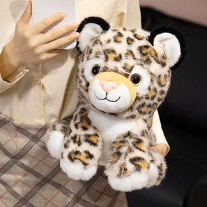 Realistic leopard plush toy with soft leopard print fur held in a cozy home setting