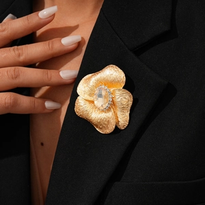 Detail of golden flower brooch with amber stone and rhinestones on a black suit blazer