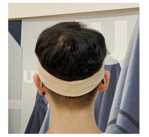 Detail showing the breathable knitted texture and elastic back fit of this beige sports headband