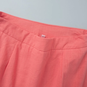 Close-up of coral pink cotton skirt waist showing refined stitching and fabric texture