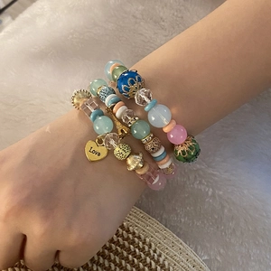 Bracciale a più strati di perline colorate con ciondolo a cuore Love dorato su sfondo morbido