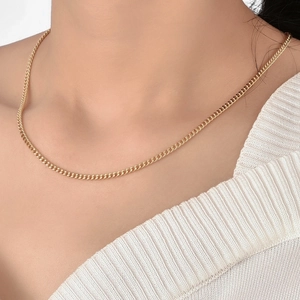 Chic gold-plated slim curb chain necklace worn by a model over a white knit top