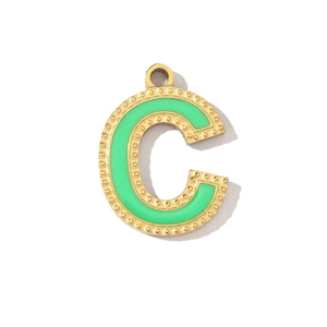 Detail view of golden letter C pendant with green enamel inlay for DIY jewelry