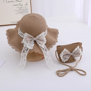 Detail of straw sun hat and matching bag with elegant white lace ribbons and satin bow
