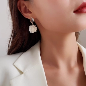 Detail of floral drop earrings with pink teardrop gem and white beaded clusters
