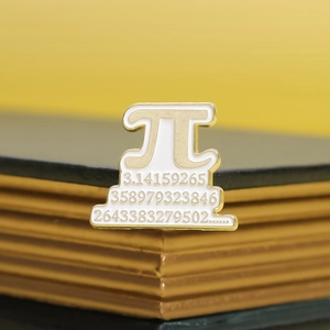 Detailed macro shot of a gold Pi symbol enamel pin with pi digits on a yellow background