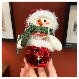 Detail of plush snowman ornament with green plaid scarf and red metal star bell