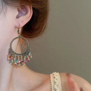 Detail of bohemian fringe earrings featuring colorful beads and antique bronze rings