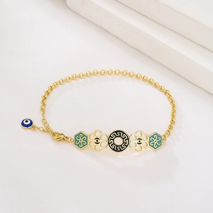 Makroaufnahme von 18K vergoldetem Armband mit blauem bösen Blick und Emaille-Anhängern