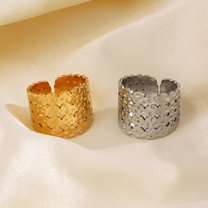 Vierschichtige breite hohle Ringe in Gold und Silber auf seidigem Stoffhintergrund