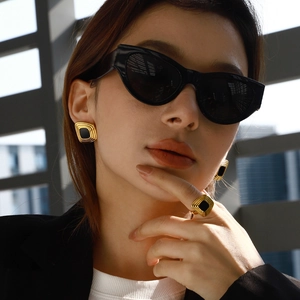 Retro geometric jewelry set with gold square earrings and ring worn by a model