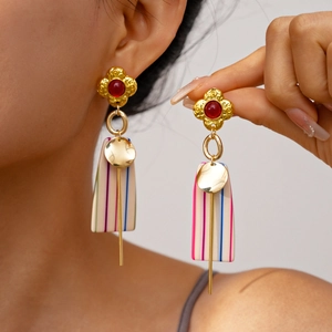 Detail view of retro geometric resin drop earrings with floral accents and striped pendants