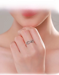 Close-up of S925 sterling silver infinity ring with pave white cubic zirconia on finger
