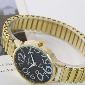 Close-up of gold-tone watch face featuring large white numerals and quartz movement