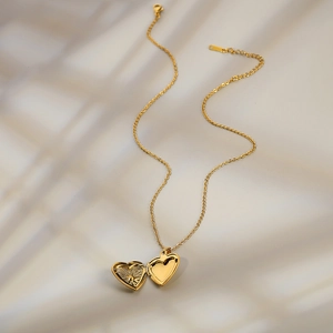 18K gold heart locket necklace with openable frame on elegant sunlit background